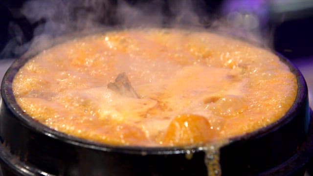 가스레인지 위 뚝배기에서 흘러넘치는 오리탕