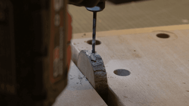 작업대에서 나무 조각에 전동 드릴 작업