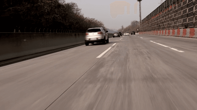 Cars running on a highway with a view of the mountains