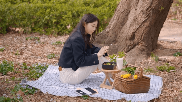 Woman enjoying picnic and eating food in park