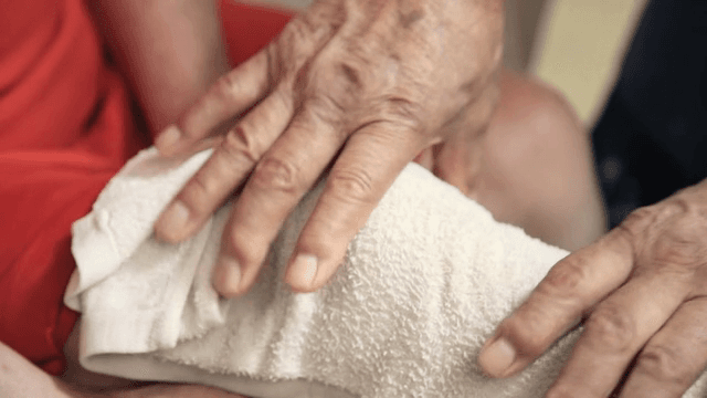 무릎에 수건을 대고 있는 노인의 손