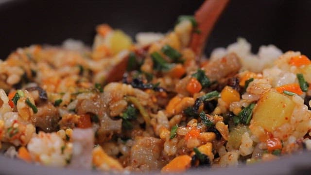 Spoonful of appetizing mussel rice with seasoning sauce