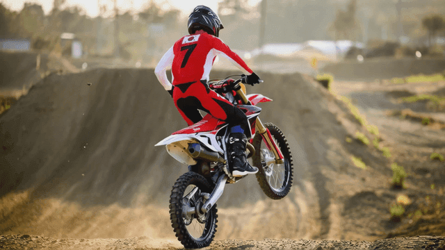 Motocross rider jumping on dirt road