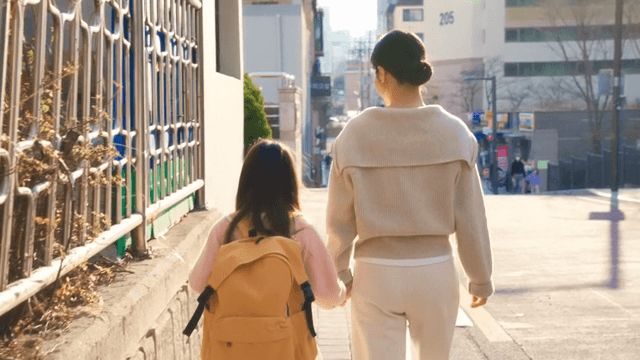 Child walking to school with her mother