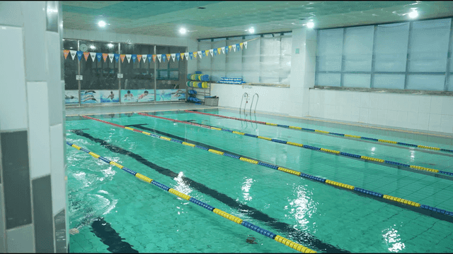 Indoor swimming pool with lanes and swimmers
