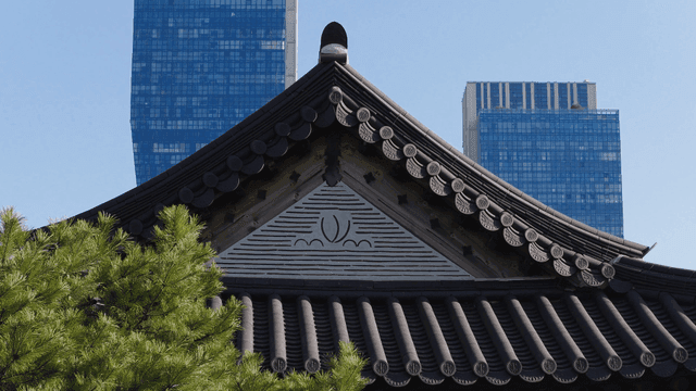 현대식 고층 건물이 뒤로 보이는 한옥 지붕