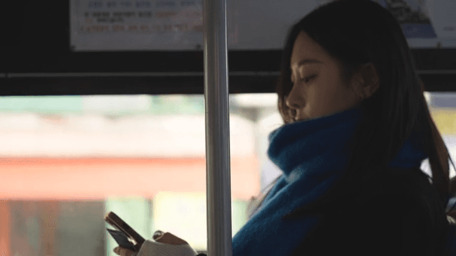 Profile of a woman using a smartphone on a bus