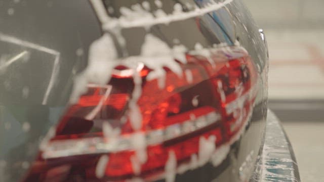 Back of a Car with Soapy Water Running Down During a Car Wash