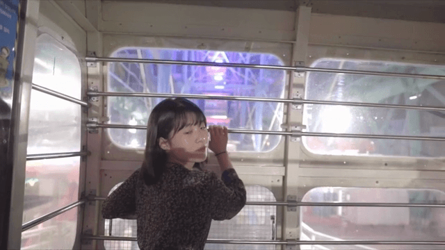 도시 불빛이 보이는 관람차 내부를 즐기는 여성