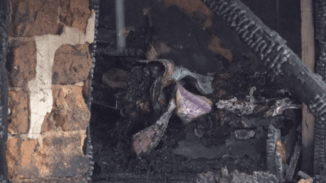 Signs of fire inside building with rain-covered debris