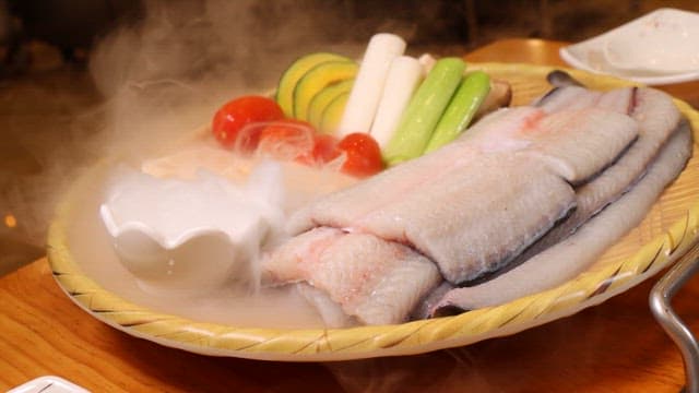 Fresh fish and vegetables in wooden basket