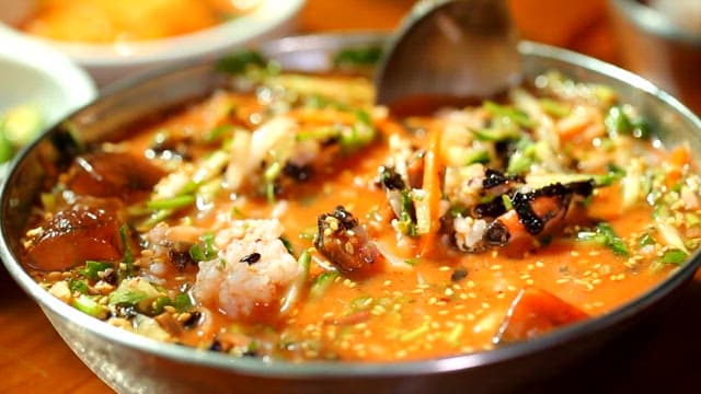 Mixing rice in a bowl of cold raw fish soup