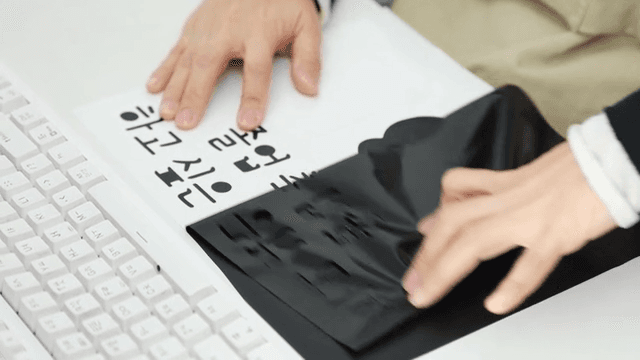 Hand peeling off black graduation congratulatory film on desk