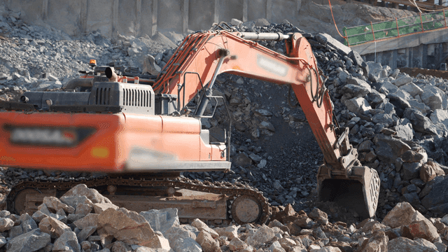 Excavator working on rocky terrain