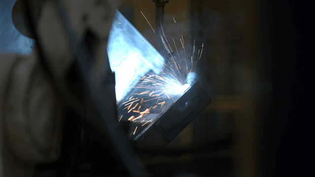 로봇 팔이 금속 부품을 용접하는 장면