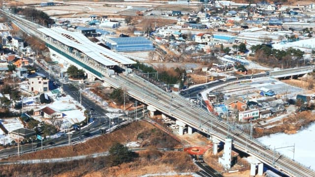 Aerial View of Trains Crossing Snowy Landscape