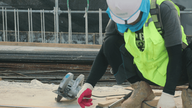 Construction worker measuring wood on site