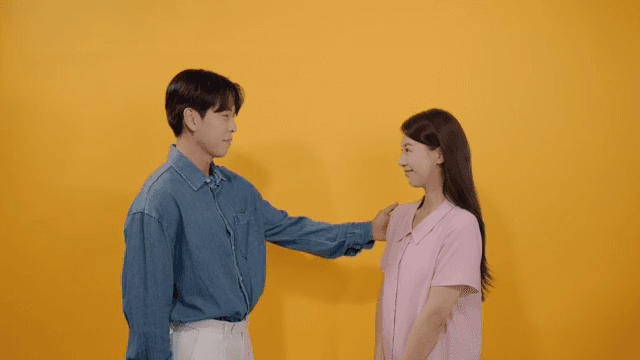 여성의 어깨를 두드리며 칭찬하는 남성