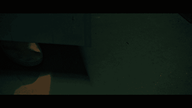 Person wearing shoes entering dark room