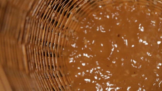 연잎으로 만든 전통 한국 술을 나무 체에 거르는 모습