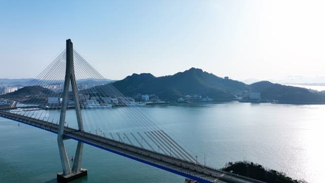 Bridge over a calm river with mountains