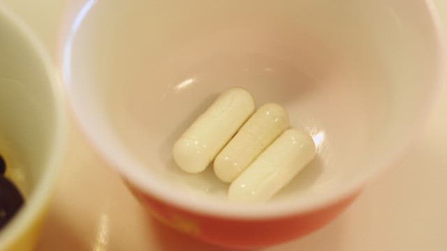 Variety of capsule nutritional supplements in a cup