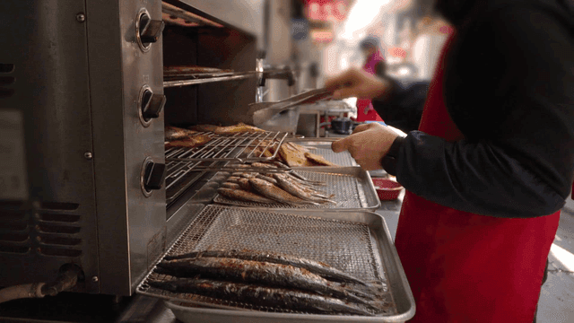 Street vendor grilling fish outdoors