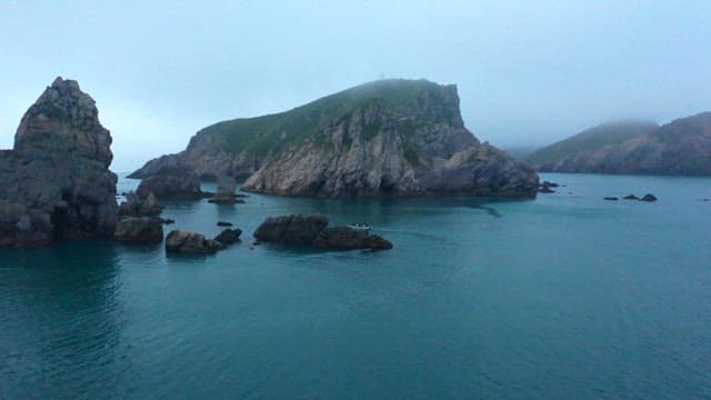 거친 절벽과 보트가 있는 고요한 바다 풍경