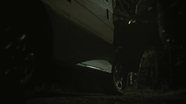 Van parked on dark forest road