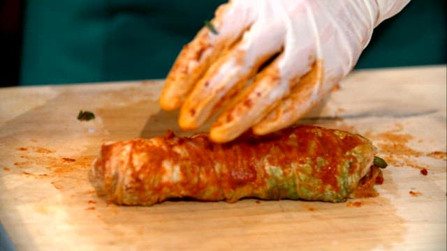 Kimchi being sliced on a wooden board