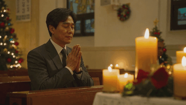 촛불이 켜진 교회에서 기도하는 남자
