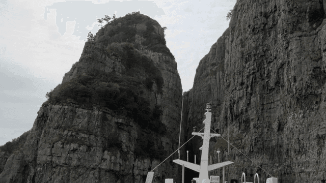 Ship sailing between high cliffs