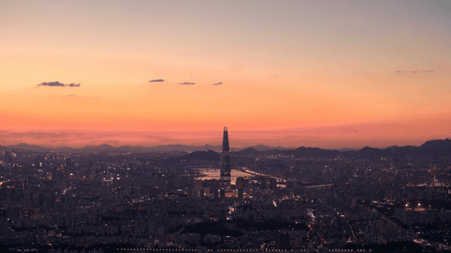 Cityscape with colorful lights and tall towers at sunset