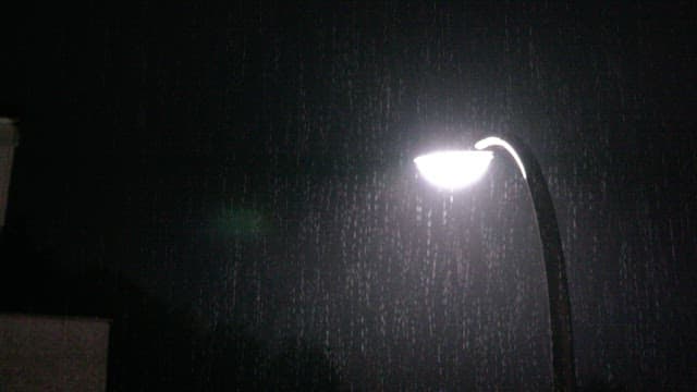 Streetlight illuminating in the pouring rain at night