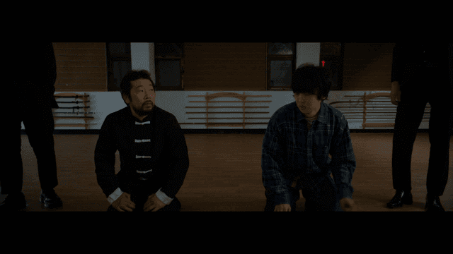 무술 도장에서의 무릎 꿇은 두 사람