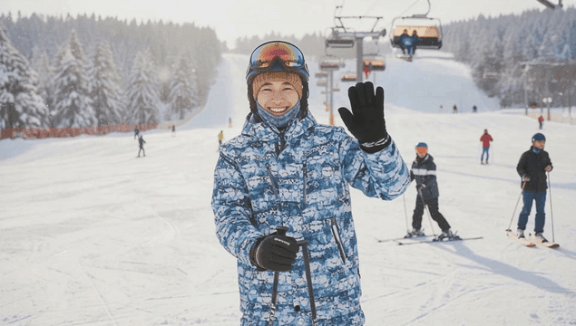 눈 덮인 스키장에서 정면을 보고 웃고 있는 스키타는 남자