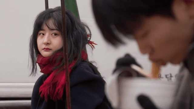 놀이터에서 라면을 먹고 있는 남성과 바라보는 여성