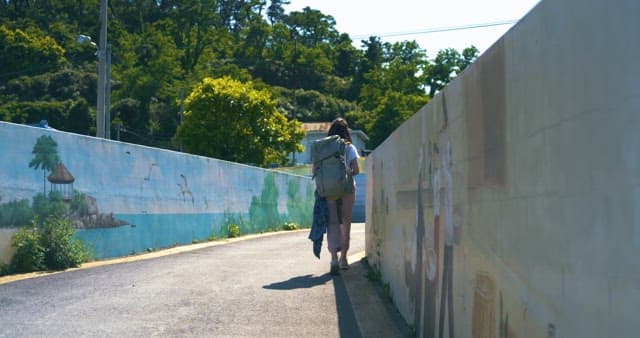 Walker by Painted Wall on Sunny Day