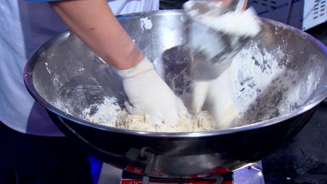 Mixing dough in a large metal container