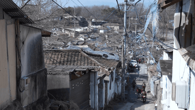 People carrying briquettes in narrow alleys of old rural village