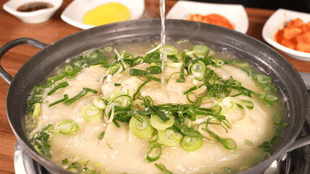 Dumpling soup with broth poured from teapot