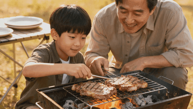 캠핑 그릴에서 스테이크를 굽는 아버지와 아들