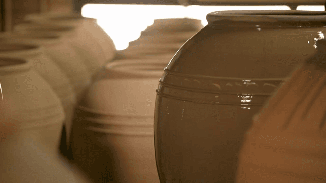 큰 도자기에 유약을 바르는 사람