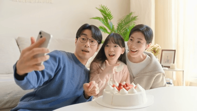 Family taking a selfie with a cake