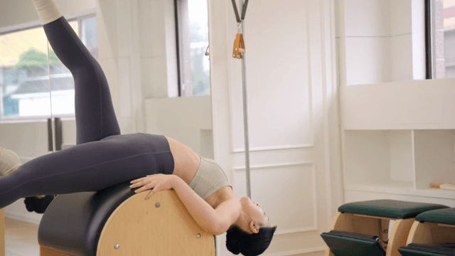 Woman exercising on a pilates barrel