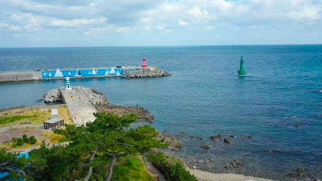 Coastal scenery with lighthouse and breakwater