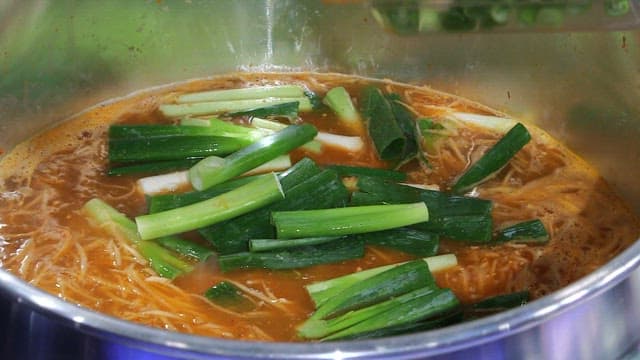끓는 찌개에 파를 넣는 장면