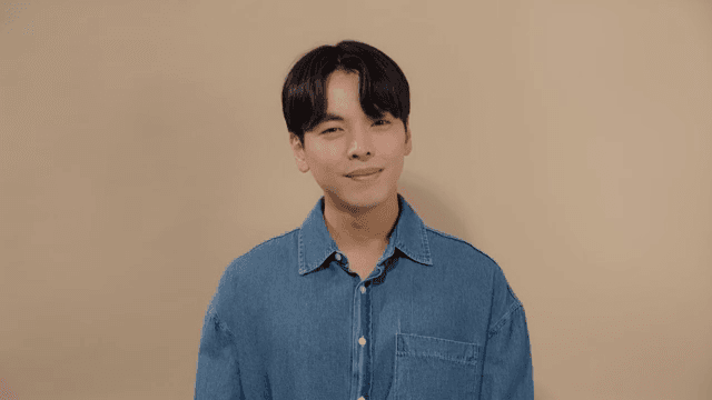 정면을 보고 편안한 미소를 짓는 데님 셔츠의 남성