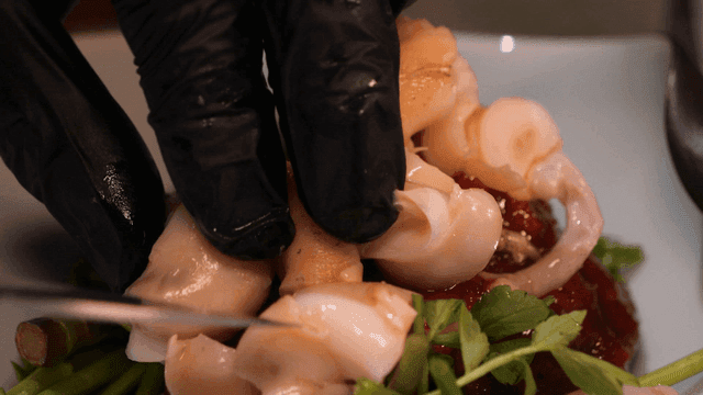 Whelk served on fresh vegetables and sauce