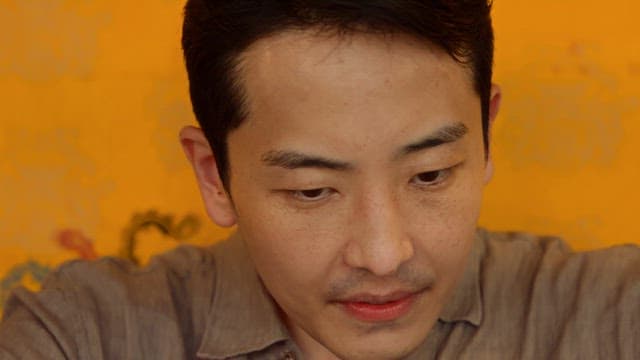 Man having a conversation in front of a yellow wall